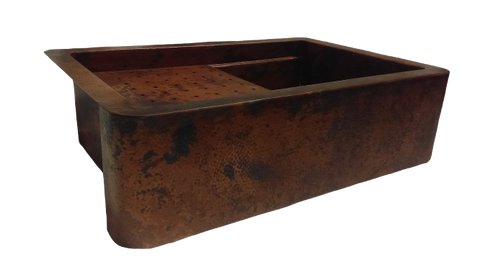 Hand-hammered copper workstation sink with round apron, featuring a spacious rectangular design and built-in accessories for enhanced kitchen functionality.