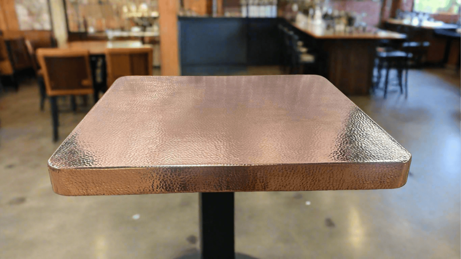 hammered copper table square shape in a beautiful bar and restaurant
