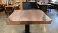 hammered copper table square shape in a beautiful bar and restaurant