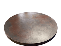 Hand-hammered copper table top glowing in natural light, highlighting its warm, rich tones and textured surface
