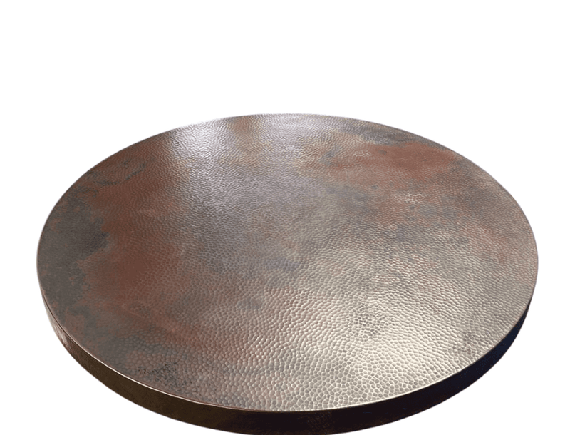 Hand-hammered copper table top glowing in natural light, highlighting its warm, rich tones and textured surface