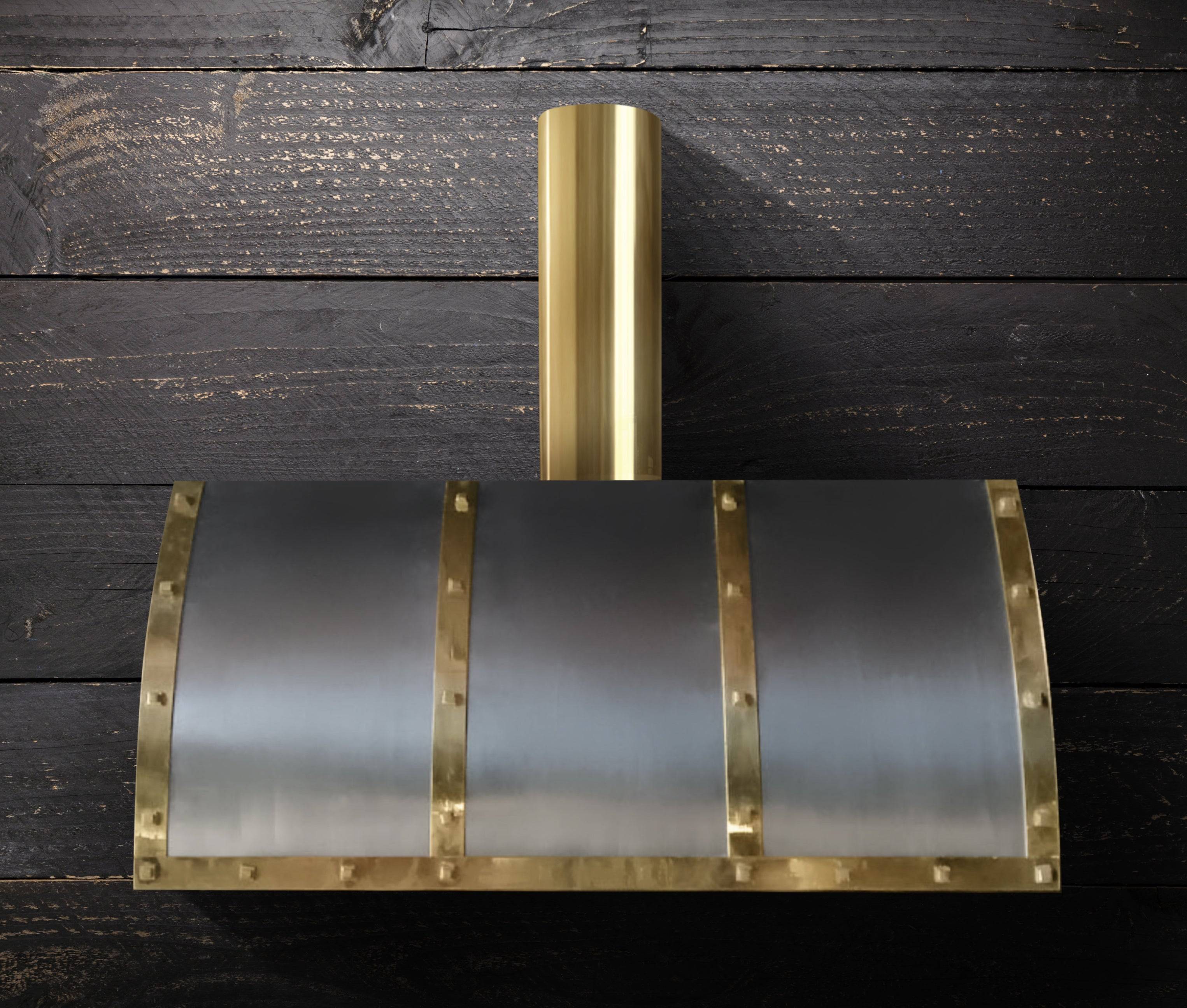 Enhance your kitchen with the Winston custom range hood by Amoretti Brothers, crafted in stainless steel and brass. This wall-mounted, barrel-shaped hood features handcrafted straps and rivets, ideal for luxury kitchen designs. Contact us for our trade program and enjoy free shipping in the USA