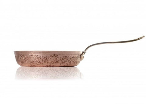 A fine copper fry pan that harkens back to Roman elegance. The classic look of the 9-inch “Leaves” Copper Fry Pan adds an elevated charm to your kitchen. Winding leaf designs cover the gleaming exterior of this fry pan. Made entirely from hand hammered copper, this copper cookware piece features a double layer of tin lining. Applied by hand, the tin layers provide an even protective coating that keeps your fry pan from wearing down.