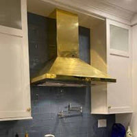 Side view of the Francesca brass range hood, emphasizing its durable construction and stylish design.