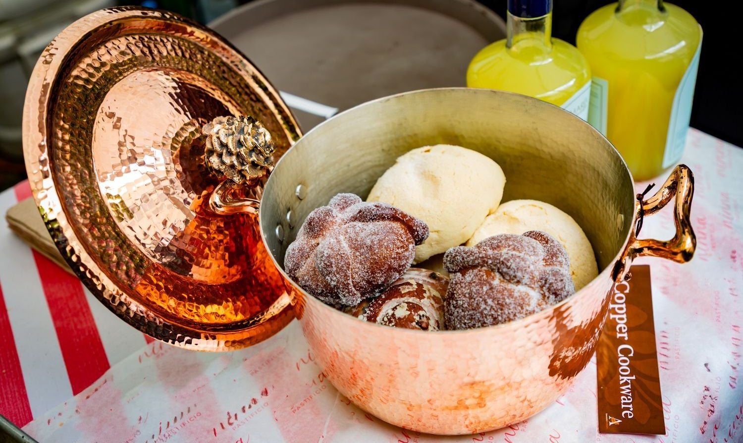 Amoretti Brothers decorative copper dutch oven with cookies on a table