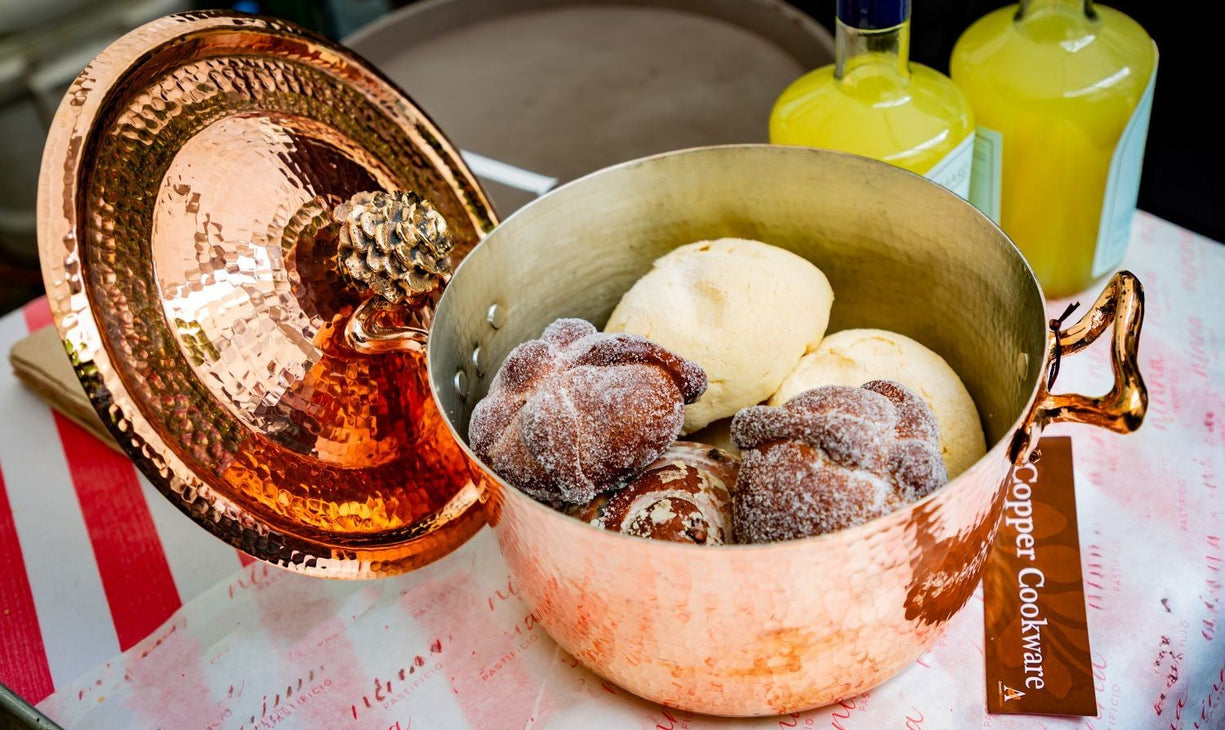 Amoretti Brothers decorative copper dutch oven with cookies on a table