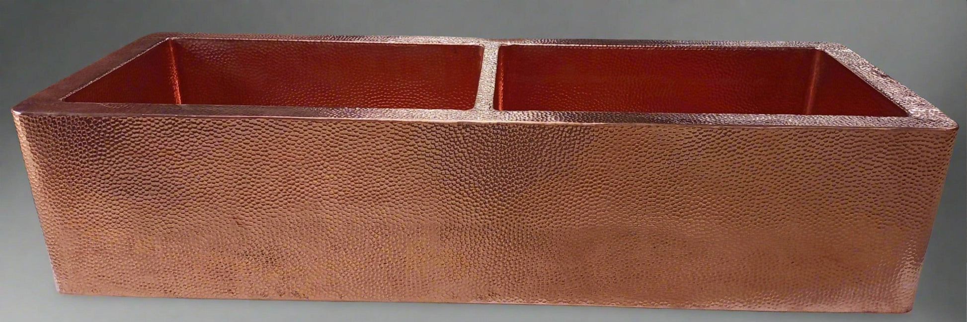 Front view of the double-bowl hammered copper kitchen sink with apron, highlighting the sink's elegant apron front and hammered finish.