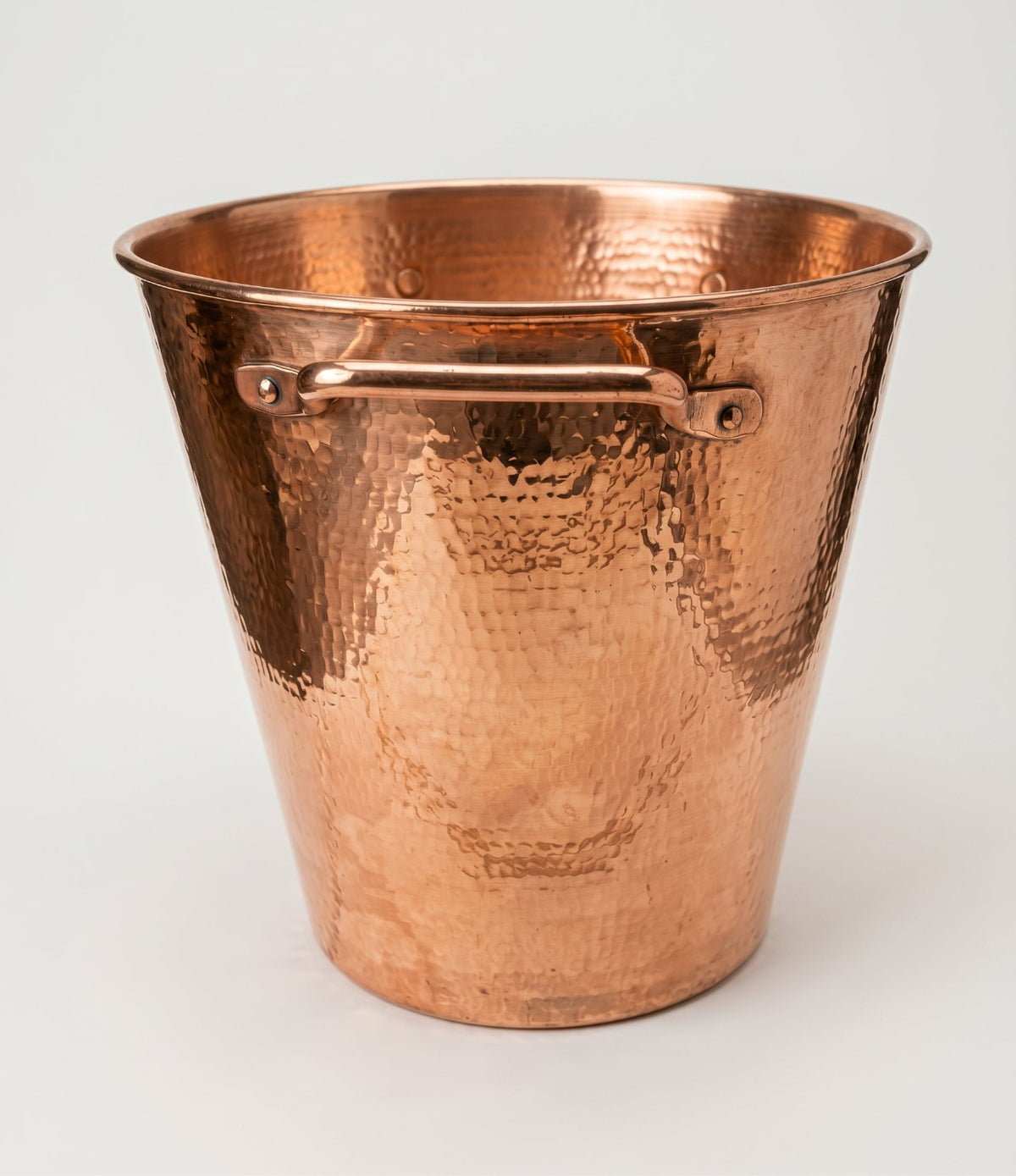 A hammered copper bucket with a side handle, shown on a clean white background.