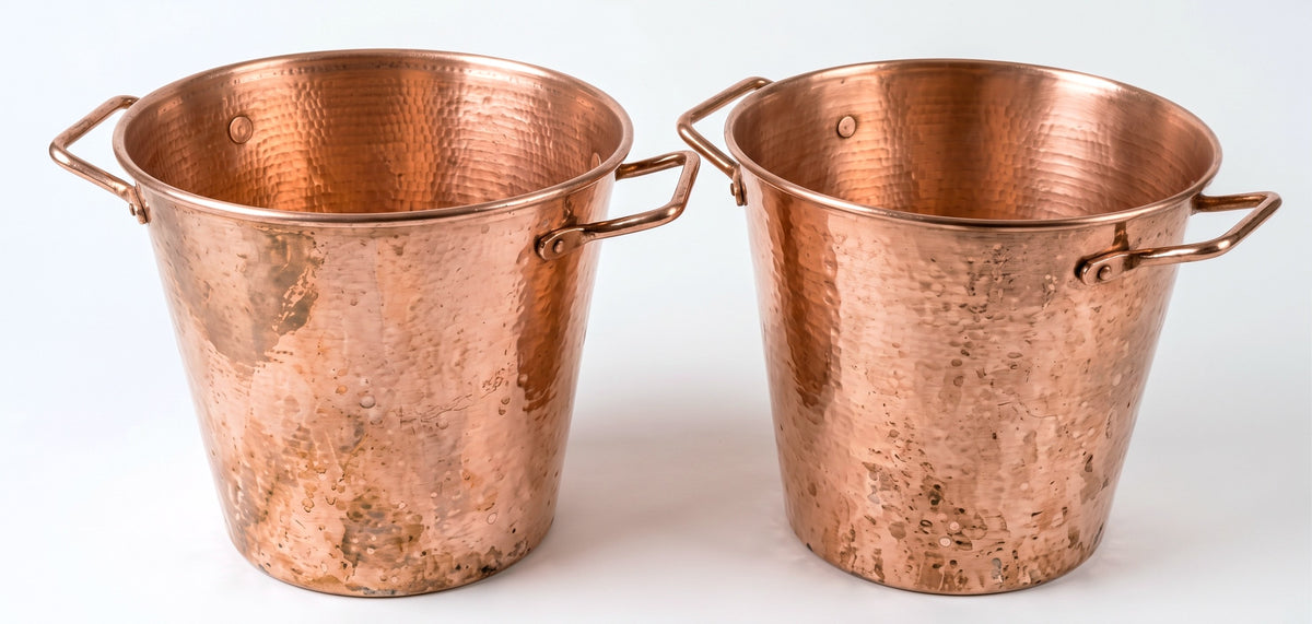Two hammered copper buckets with side handles, shown on a plain white background.