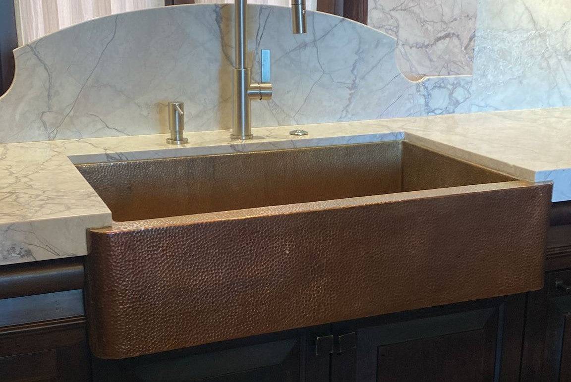 Single ball hammered copper sink with a dark patina, featuring a rustic, textured finish and elegant, deep hues