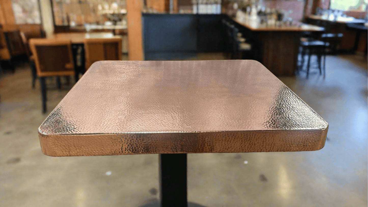 hammered copper table square shape in a beautiful bar and restaurant 