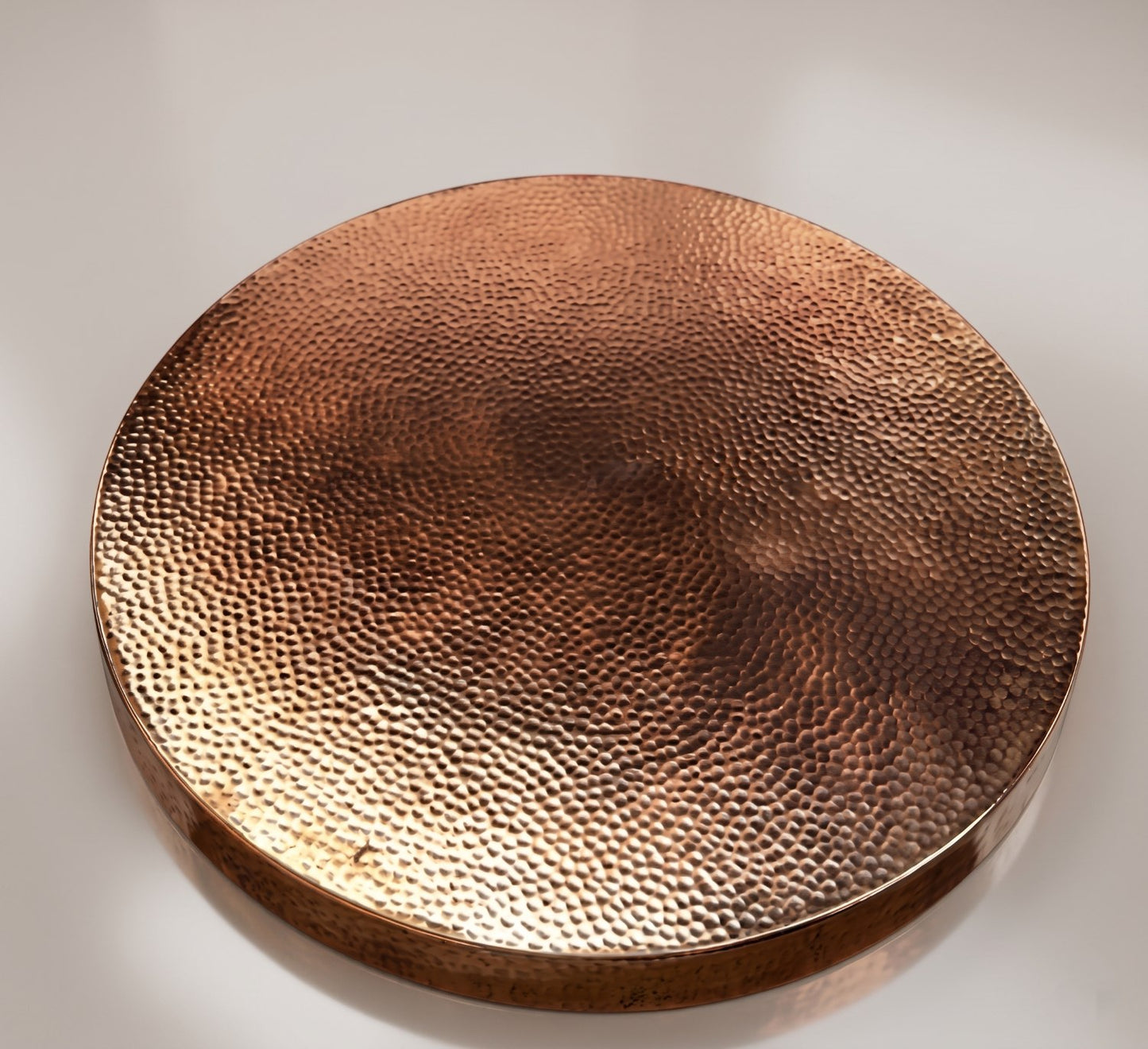 Round copper tray with a textured surface on a light background