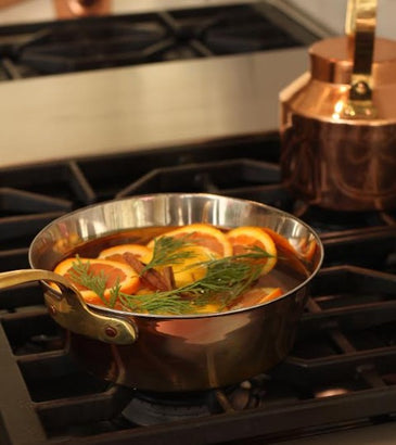 Close-up of the double-layered copper and stainless steel Windsor warming pan with food, highlighting even heat distribution for perfect warming.