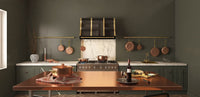 Amoretti Brothers kitchen with a copper table, a custom brass range hood, copper cookware and pots racks