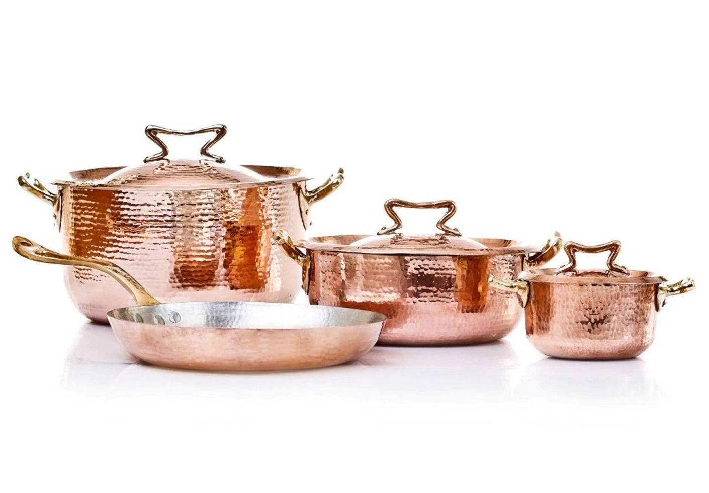 A set of four polished copper cookware pieces with cast bronze handles and lids, including a cocotte, sauté pan, saucepan, and frying pan. Amoretti Brothers