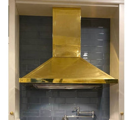 Francesca brass range hood in a contemporary kitchen, highlighting its sleek and stylish design amidst modern decor.