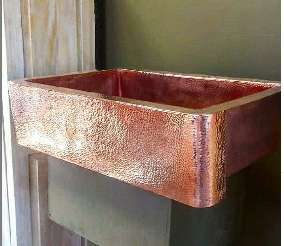 Hand-hammered copper apron sink by Amoretti Brothers with a distinctive textured finish and classic design